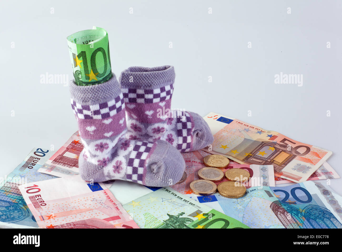 Kinder Socken und Euro Banknoten. Beihilfen und Unterstützungen., Kindersocken Und Euro-Geldscheine. Beihilfen Und Foerderungen. Stockfoto