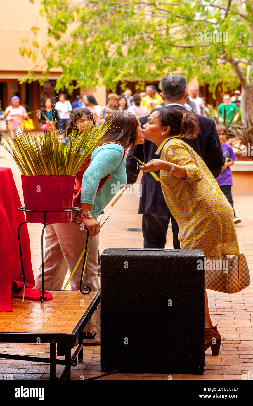 Hispanische Mitglieder der katholischen Kirche St. Timothy, Laguna Niguel, CA, grüßt einander mit einem Kuss nach der Einnahme Palmwedel vor Palmsonntag Masse. Stockfoto