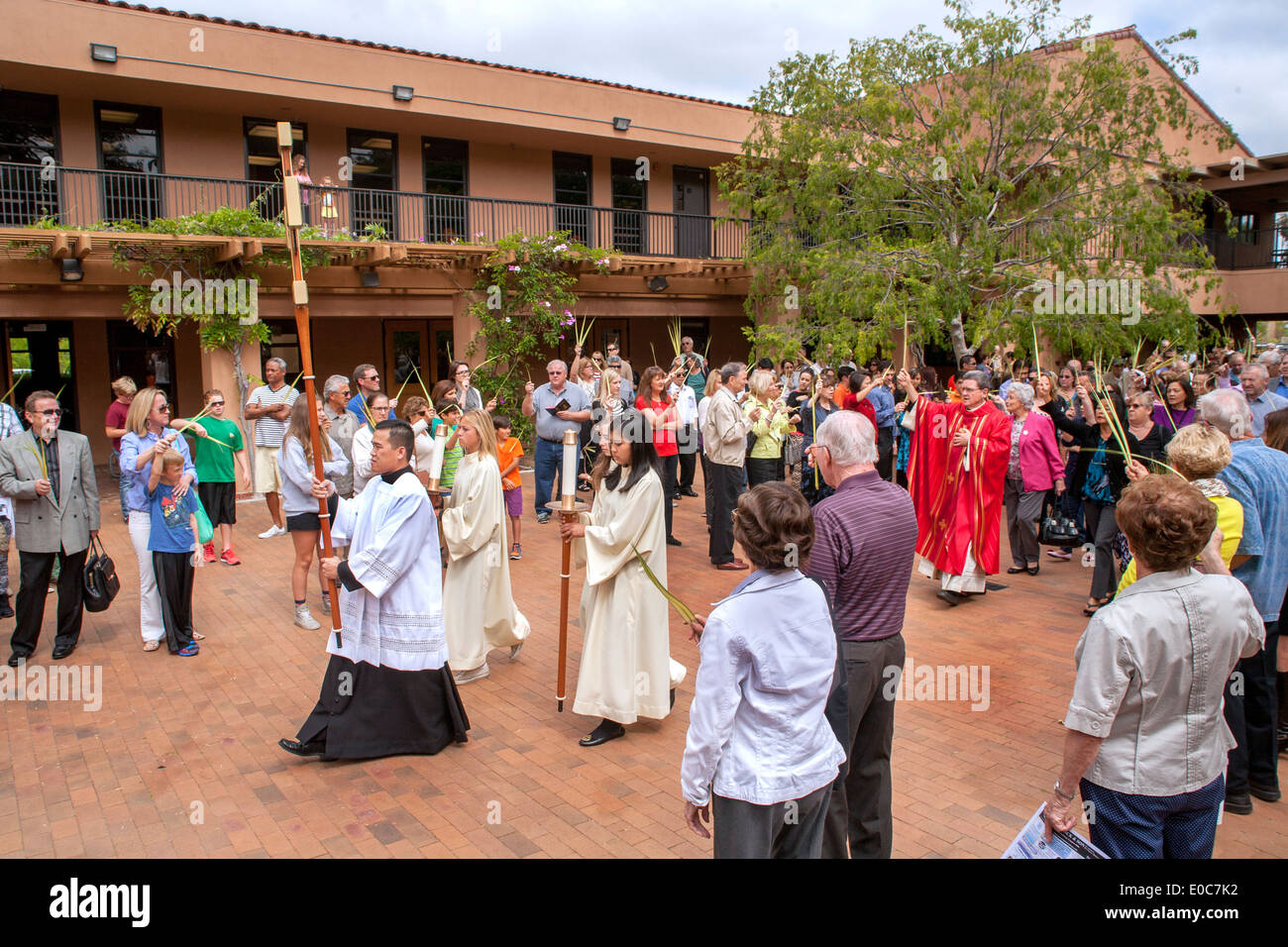 Eine vietnamesischen Seminaristen Intern das Halten eines Kreuzes führt eine Prozession zu Palmsonntag Messe in St. Timothy katholische Kirche, Laguna Niguel. CA. Hinweis Palmwedel von Gemeinde und Pastor in rot gehalten. Stockfoto