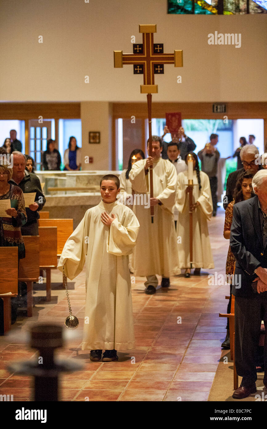 Ministranten führen eine Prozession vor der Messe in der katholischen Kirche St. Timothy, Laguna Niguel, CA. Hinweis Kreuz, Gewänder und Räuchergefäß (Weihrauch-Brenner). Stockfoto