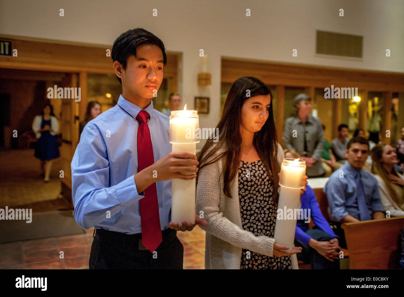 Mit Kerzen, bereiten junge Ministranten, den Gang der katholischen Kirche St. Timothy, Laguna Niguel, CA, zu Beginn der Osternacht Masse hinunter zu marschieren. Stockfoto