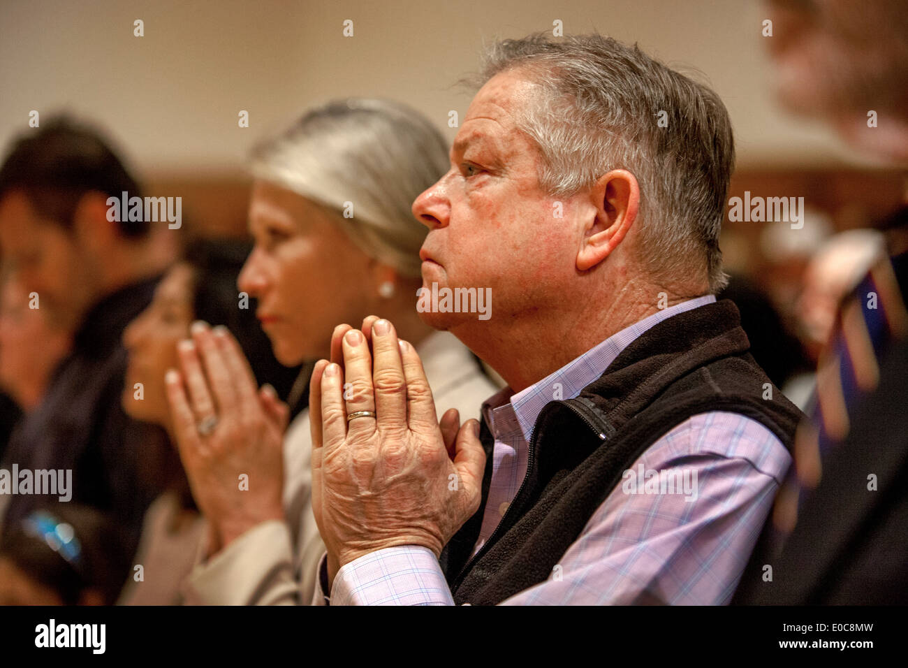 Gemeindemitglieder halten ihre Hände im Gebet während der Messe in der St. Timothy katholische Kirche, Laguna Niguel, CA Stockfoto
