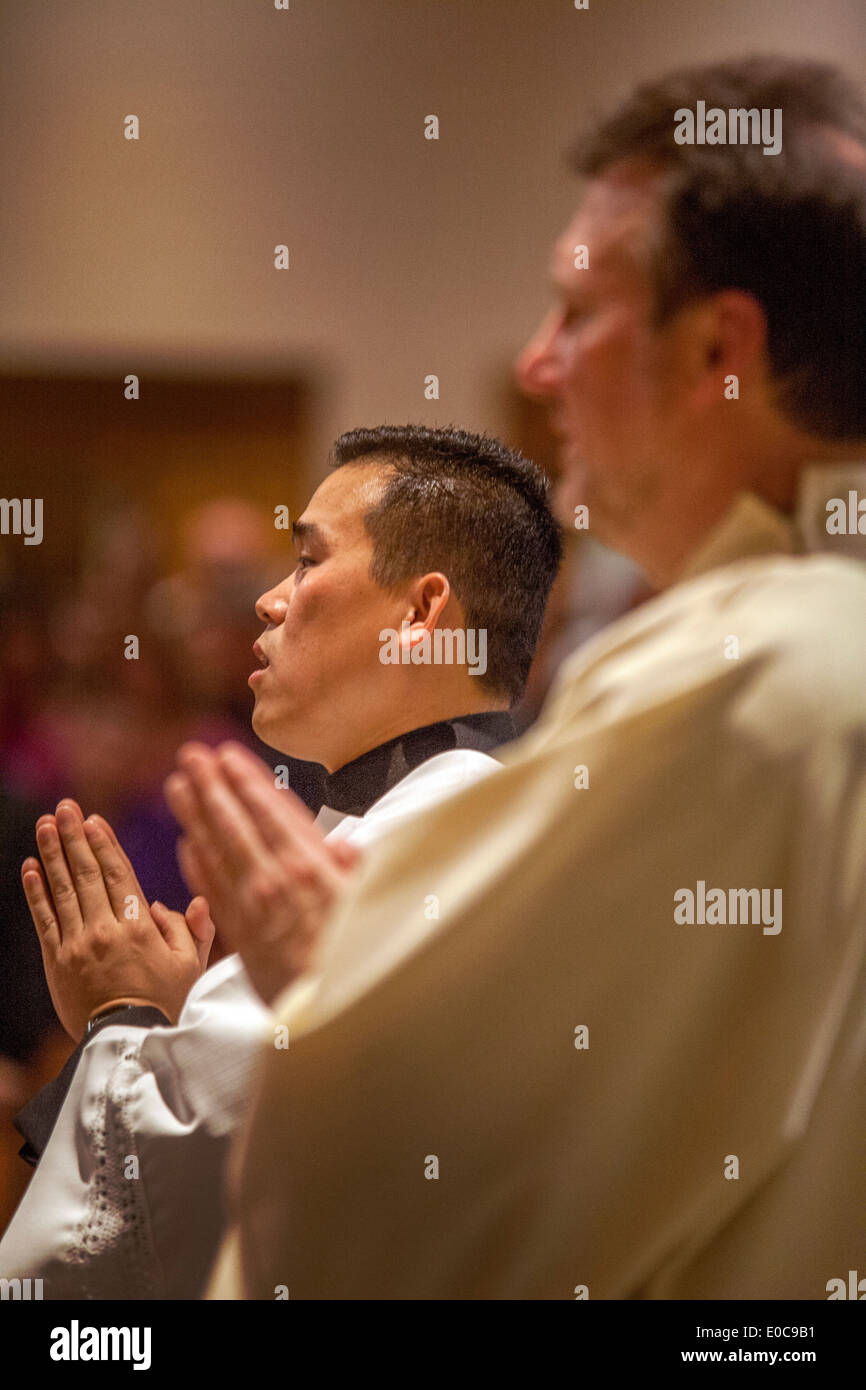 Die asiatisch-amerikanische Hilfsprediger der St. Timothy katholische Kirche, Laguna Niguel, CA, Gebete während der Messe. Beachten Sie die Roben. Stockfoto