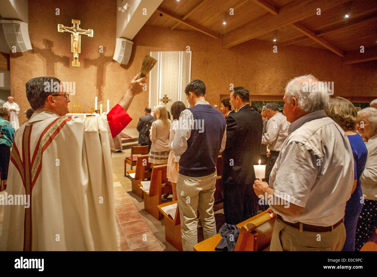 Zum Abschluss der großen Masse der Osternacht streut die Pfarrer von St. Timothy katholische Kirche, Laguna Niguel, CA, Weihwasser über seine Gemeinde mit einer steifen Bürste. Stockfoto