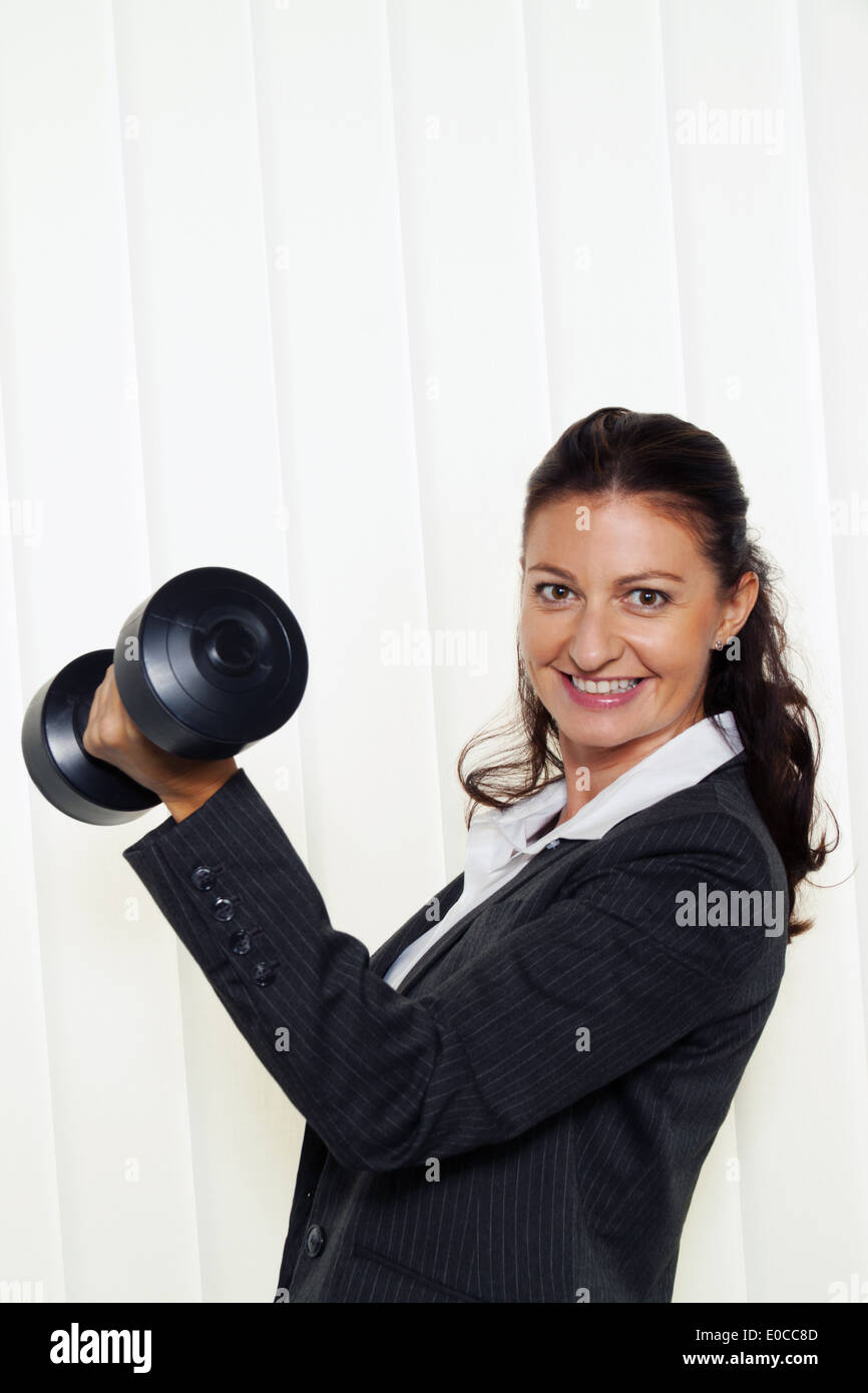 Junge, erfolgreiche Unternehmer im Büro. Wenn eine Hantel, Junge, Erfolgreiche Unternehmerin Im Buero hält. Haelt Eine Hantel Stockfoto