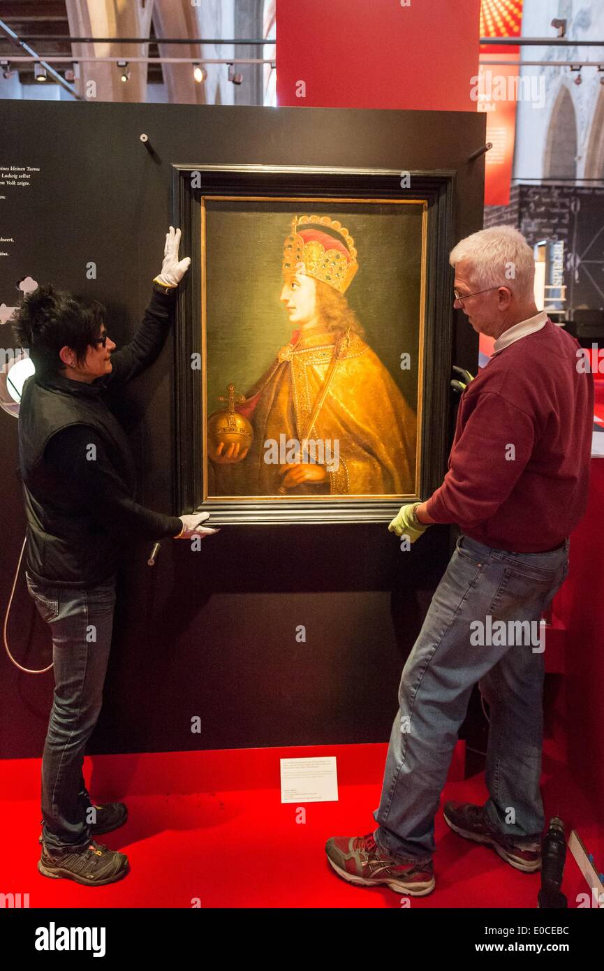 Mitarbeiter hängen ein Gemälde von Kaiser Ludwig IV. in einem Ausstellungsraum der Ausstellung "Ludwig der Bayer. Wir Sind Kaiser "(Ludwig von Bayern. Wir sind Kaiser) in der Minoritenkirche in Regensburg, Deutschland, 08. Mai 2014. Die Ausstellung konzentriert sich auf die erste Wittelbachs, der Kaiser des Heiligen Römischen Reiches wurde. Foto: ARMIN WEIGEL/dpa Stockfoto