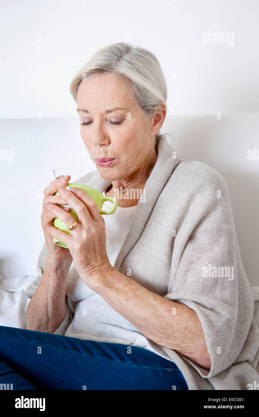 Ältere Person mit Heißgetränk Stockfoto