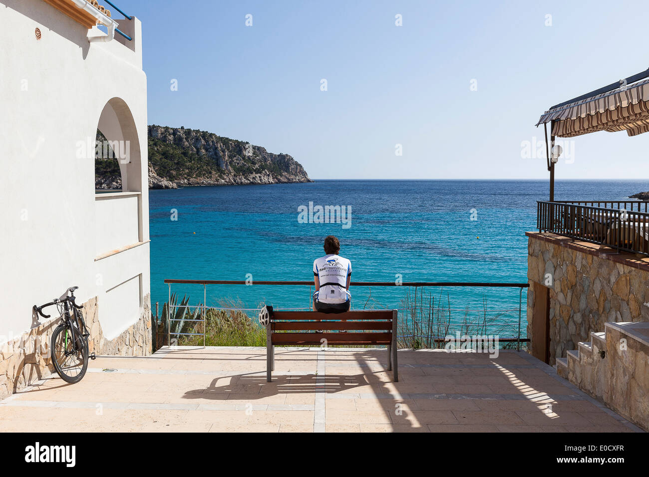 Radfahrer, ruht auf einer Bank am Mittelmeer-Küste, Sant Elm, Mallorca, Balearen, Spanien Stockfoto