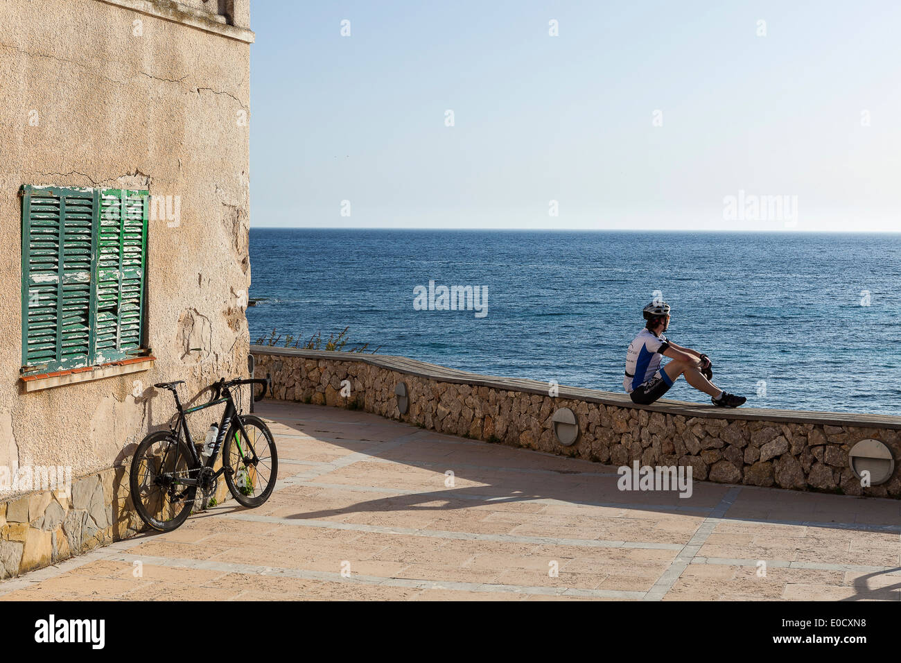 Radfahrer, ruht auf einem Einkaufszentrum an der Mittelmeerküste, Sant Elm, Mallorca, Balearen, Spanien Stockfoto