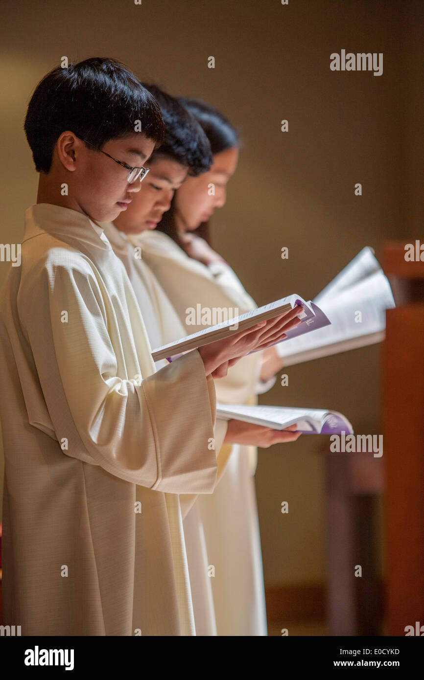 Junge gekleidet Ministranten tägliche Missale zu lesen, da man Gründonnerstag Messe in St. Timothy katholische Kirche, Laguna Niguel, CA teilnimmt. Stockfoto
