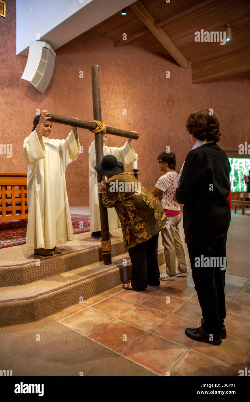 Während der Karfreitag-Messe in der St. Timothy katholische Kirche teilnehmen Laguna Niguel, CA, Gemeindemitglieder an der feierlichen Kreuzverehrung. Beachten Sie die Roben Ministranten. Stockfoto