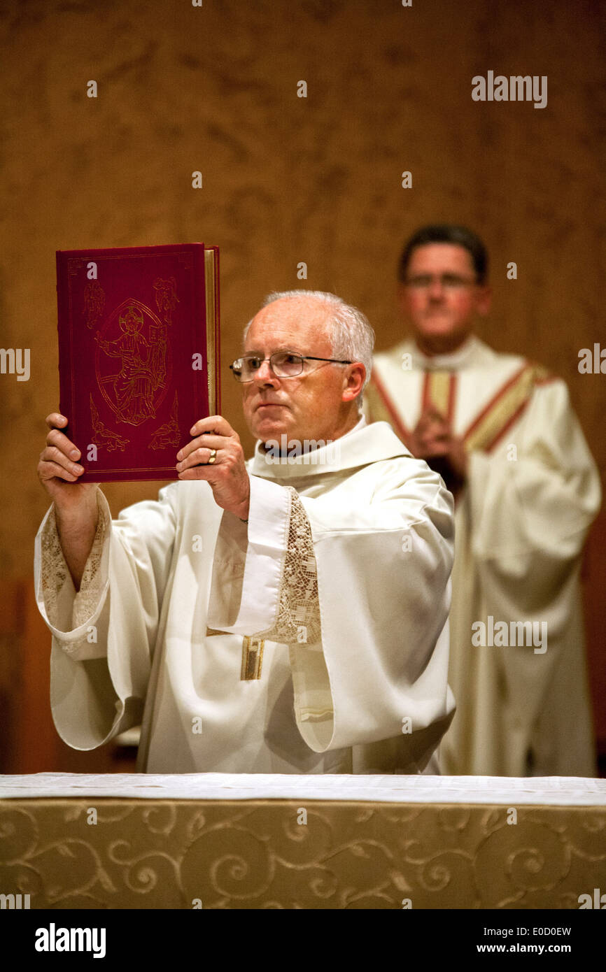 Eine ältere Diakon hält das Evangelium während der großen Osternacht-Messe in St. Timothy katholische Kirche, Laguna Niguel, CA. Hinweis Pastor im Hintergrund. Stockfoto