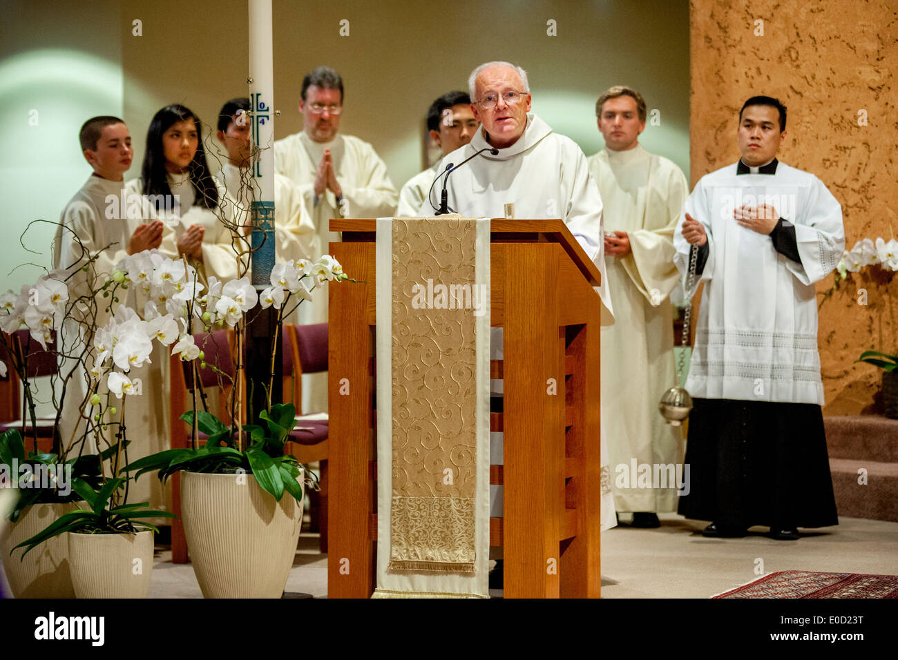 Diakon der katholischen Kirche St. Timothy, Laguna Niguel, CA, liest das Evangelium. Beachten Sie vietnamesische Assistent Pastor & Altar Server Stockfoto