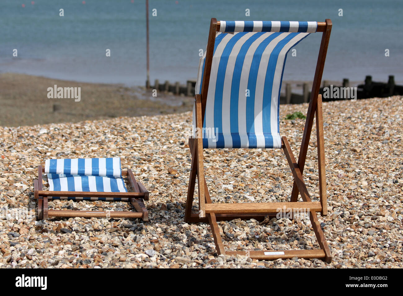 Blaue & weiß gestreiften Liegestühlen Whitstable Strand, Kent, England UK. Bank Holiday Stockfoto