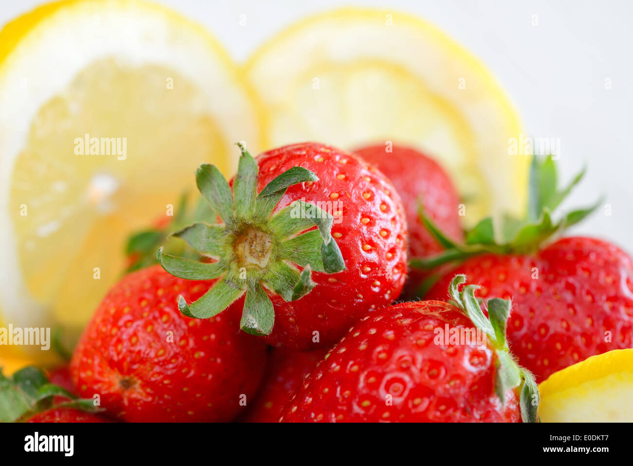 Frische natürliche rote Erdbeeren und in Scheiben geschnittene Zitrone Stockfoto
