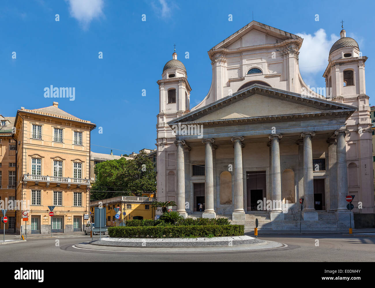 Kleine Stadtplatz mit Kreisverkehr umgeben von Gebäuden und katholische Kirche in Genua, Italien. Stockfoto