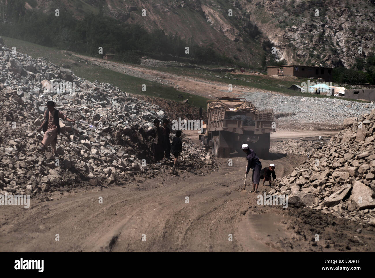 Badakhshan. 6. Mai 2014. Afghanische Kinder entfernen Steinen von einer hohen Weise nach einer schweren Überschwemmung in der Badkhshan Provinz im Norden Afghanistans, 6. Mai 2014. Mehr als 10.000 Kilometer Autobahnen und Hauptstraßen wurden rekonstruiert und über das Land seit dem Sturz des Taliban-Regimes Ende 2001 asphaltiert. © Ahmad Massoud/Xinhua/Alamy Live-Nachrichten Stockfoto