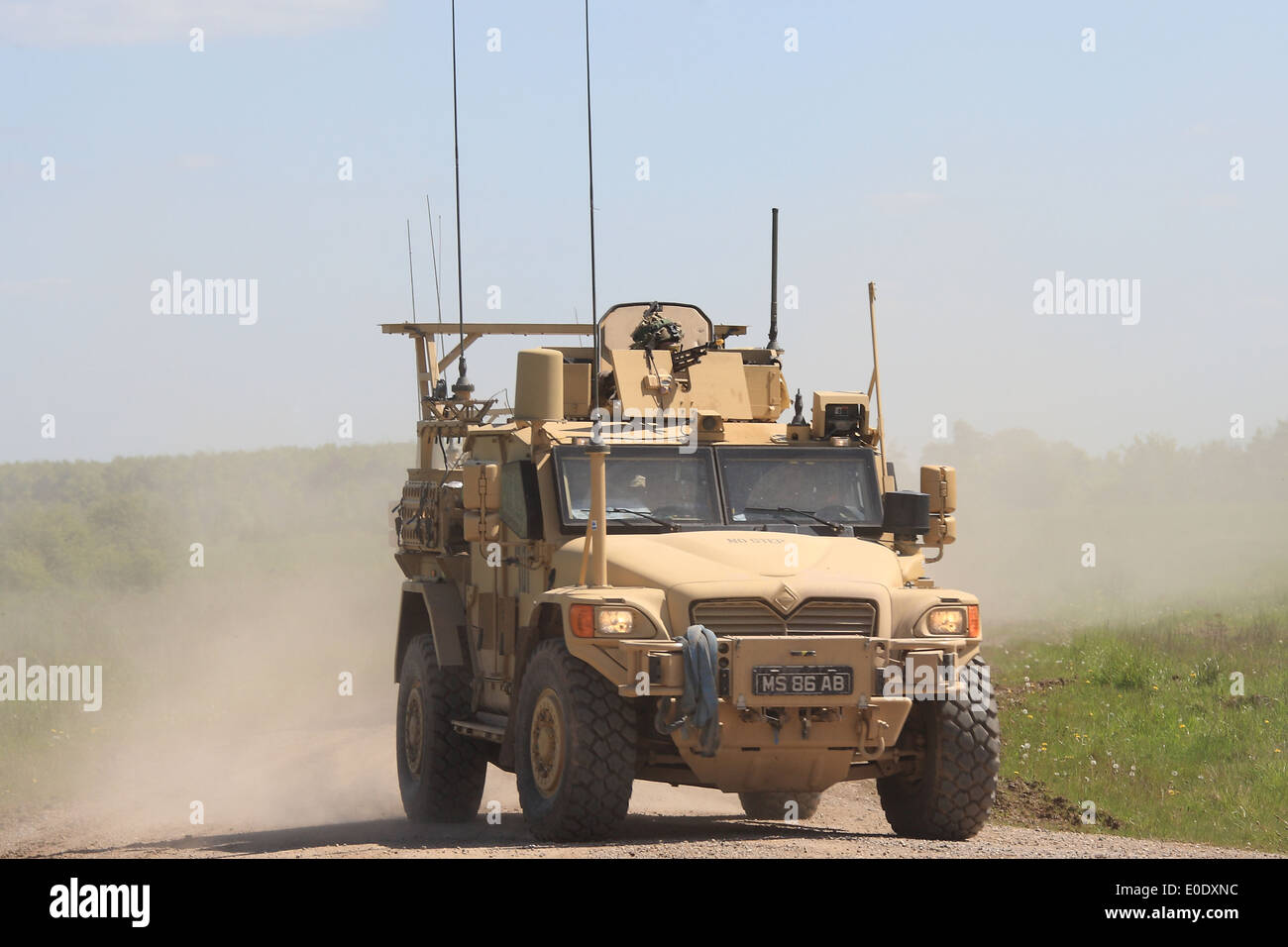 Britische Armee Husky geschützt Begleitfahrzeug schafft eine Staubwolke Übertragung Geschwindigkeit über unwegsames Gelände. Stockfoto