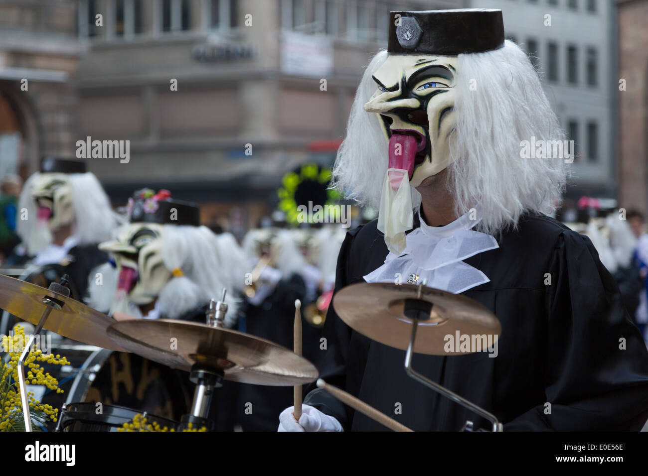 Ein Foto von einer Parade Teilnehmer in eine weiße Perücke verkleidet und Schlagzeug zu spielen, auf einem Jahrmarkt in Europa. Stockfoto