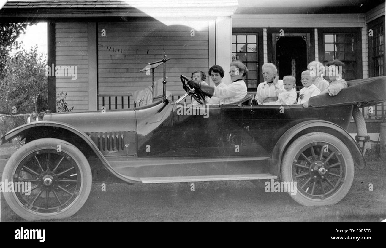 Dieses Foto zeigt eine Gruppe von Frauen und Kindern in einem Auto. Das Bild stammt aus dem frühen 20. Jahrhundert und spiegelt das Familienleben und den Transport während dieser Zeit wider. Stockfoto