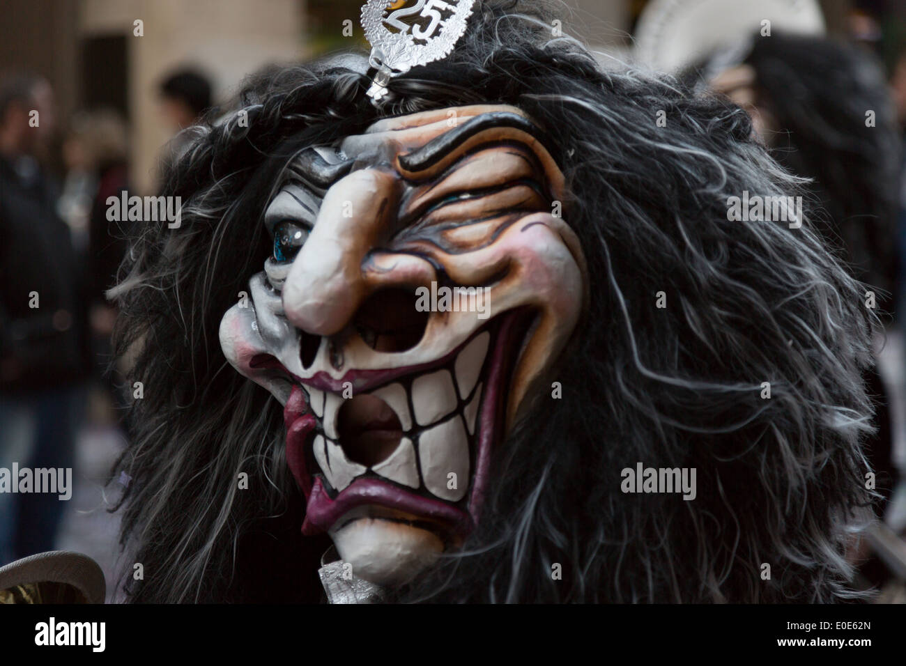 Eine Nahaufnahme Foto einer grinsenden Gesicht Maske mit einer schwarzen  Perücke am Basler Fasnacht (Karneval), in der Schweiz Stockfotografie -  Alamy