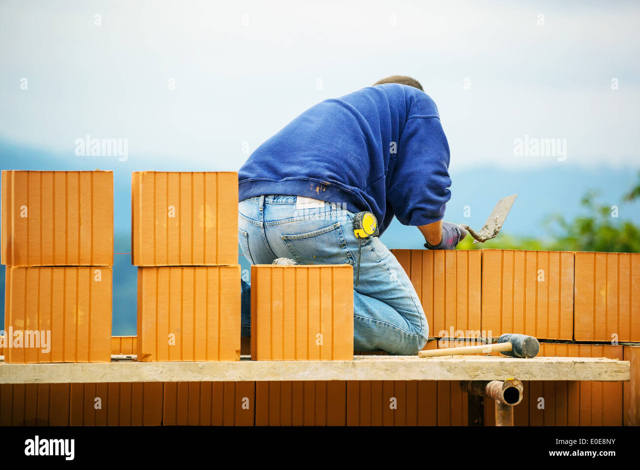 Bauarbeiter, die ihm aus einer Schale aus Ziegeln zu etablieren. Illegale Beschäftigung und Pfusch auf der Baustelle Bauarbeiter Höhle Stockfoto
