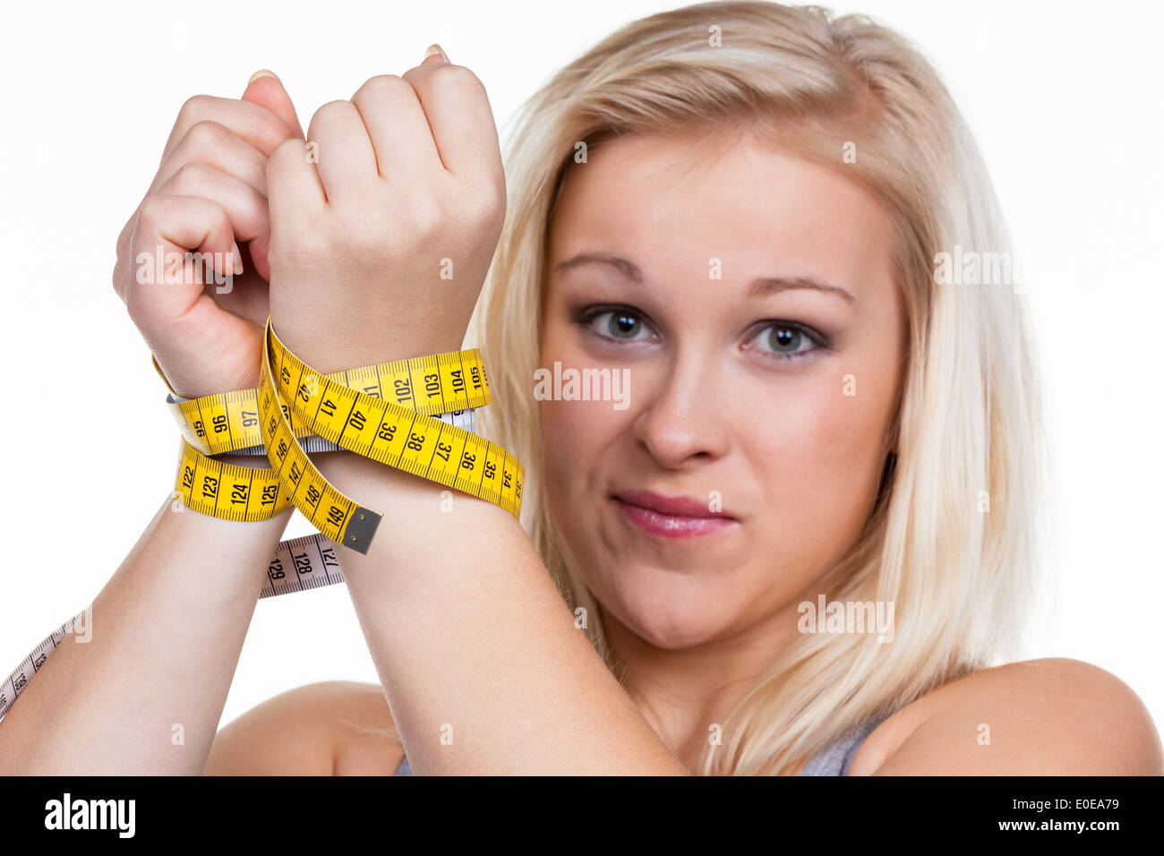 Eine junge Frau mit einer Dimension Band vor der nächsten Diät Stockfoto