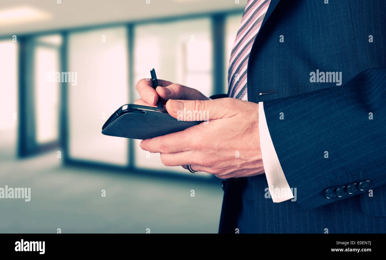 Ein Geschäftsmann, ein Schreiben mit einem Stift auf einem elektronischen Gerät. Stockfoto