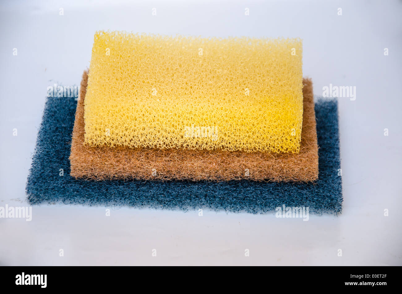 gelbe und blaue Schwamm zum Reinigen auf weißem Hintergrund Stockfoto