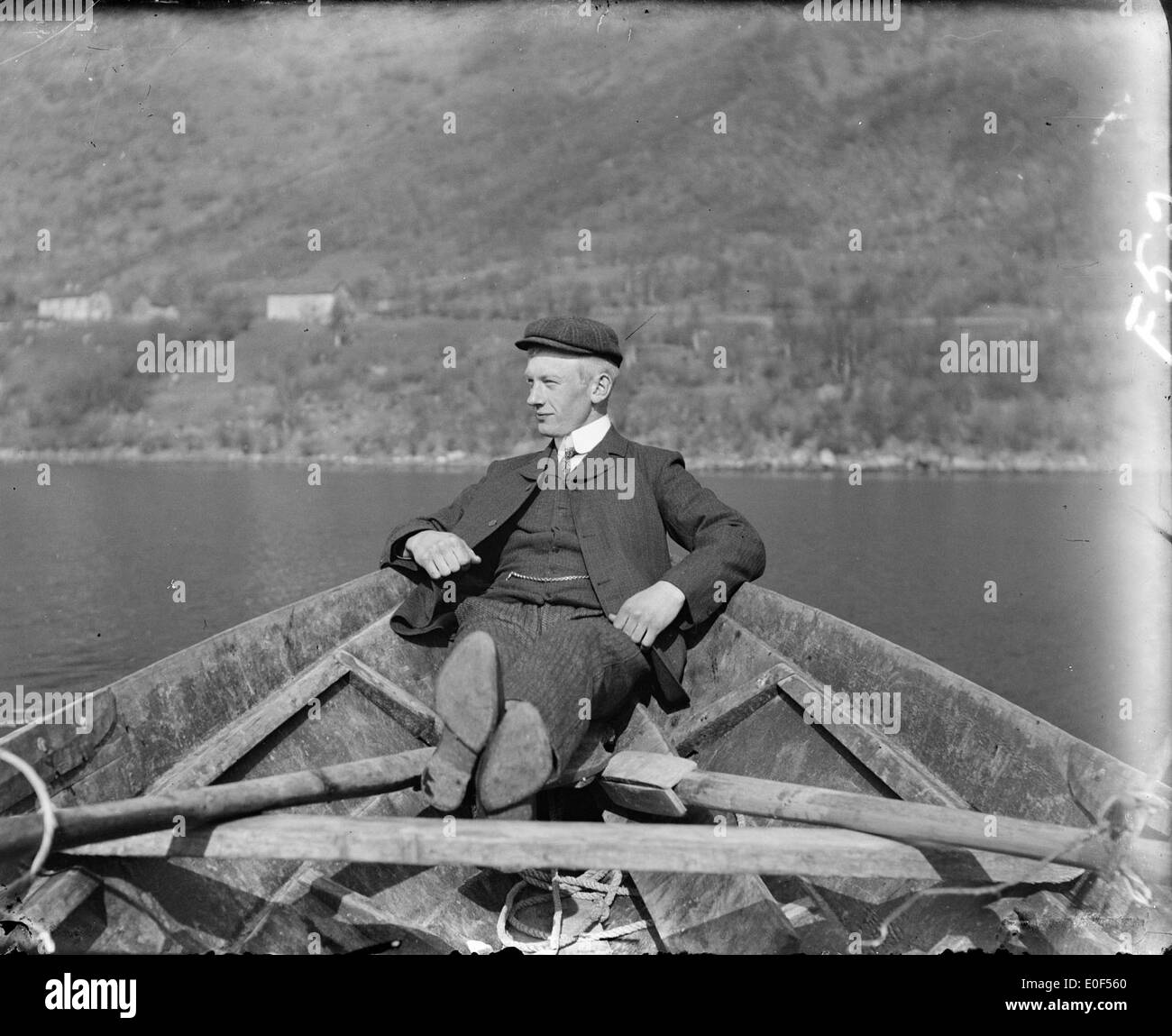 Dieses alternative Foto zeigt eine Vintage-Szene der Fjorde in Norwegen mit einem alten Ruderboot auf dem Wasser. Das Bild spiegelt die landschaftliche Schönheit und das historische Leben rund um Norwegens Fjorde wider. Stockfoto