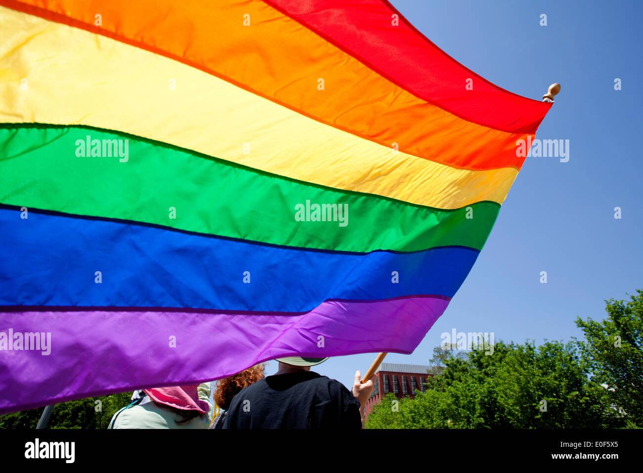 Person, die eine Regenbogenfahne auf LGBT Kundgebung - Washington, DC USA Stockfoto