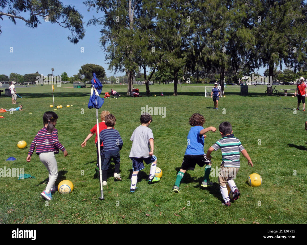 Kinder Praxis dribbling Fußball im Sommercamp im park Stockfoto