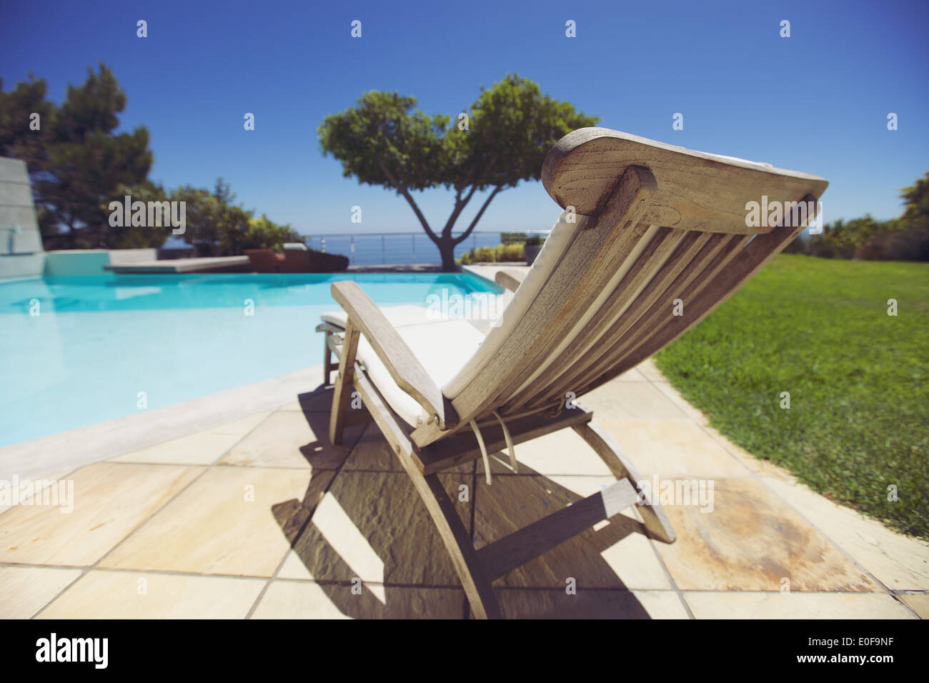 Langen Liegestuhl am Pool. Leer aus Holz Liegestuhl am Pool im Holiday Resort. Stockfoto