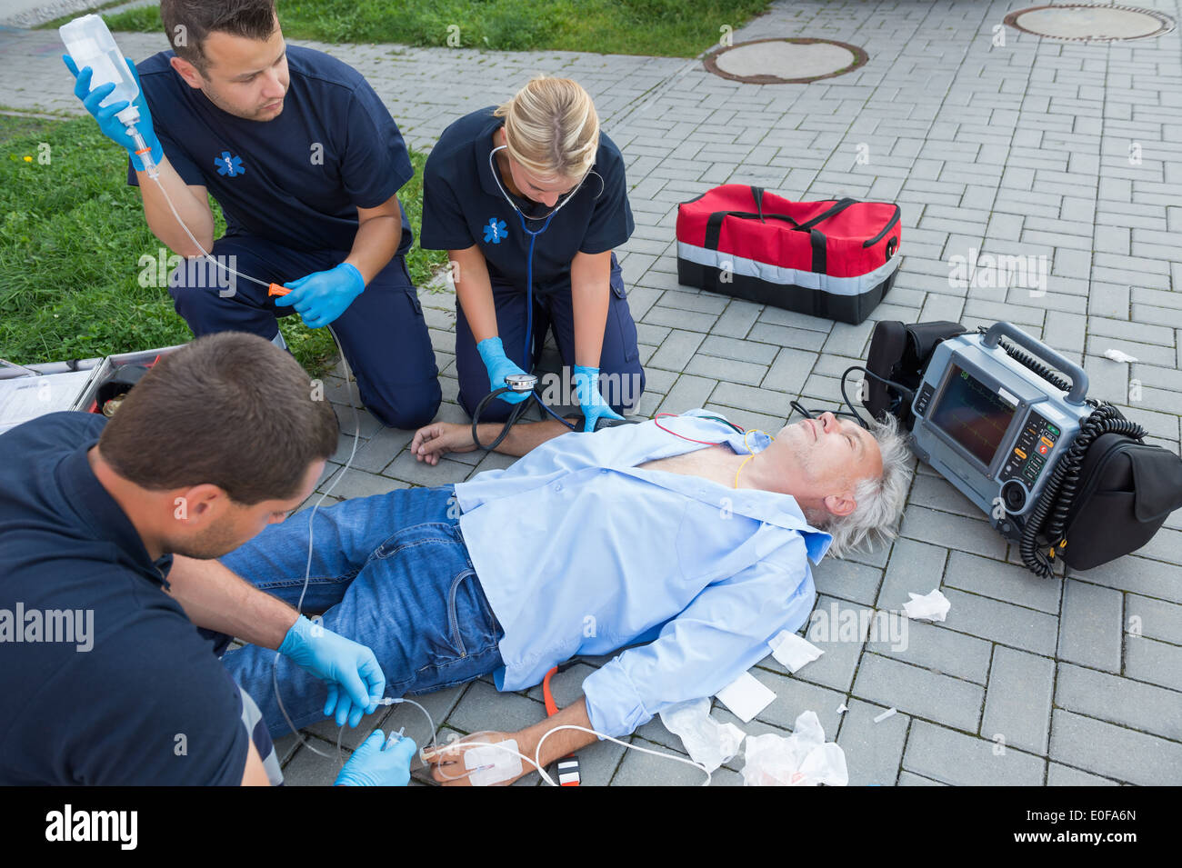 Notfall-Team geben ers verletzter älterer Patient auf Straße Stockfoto