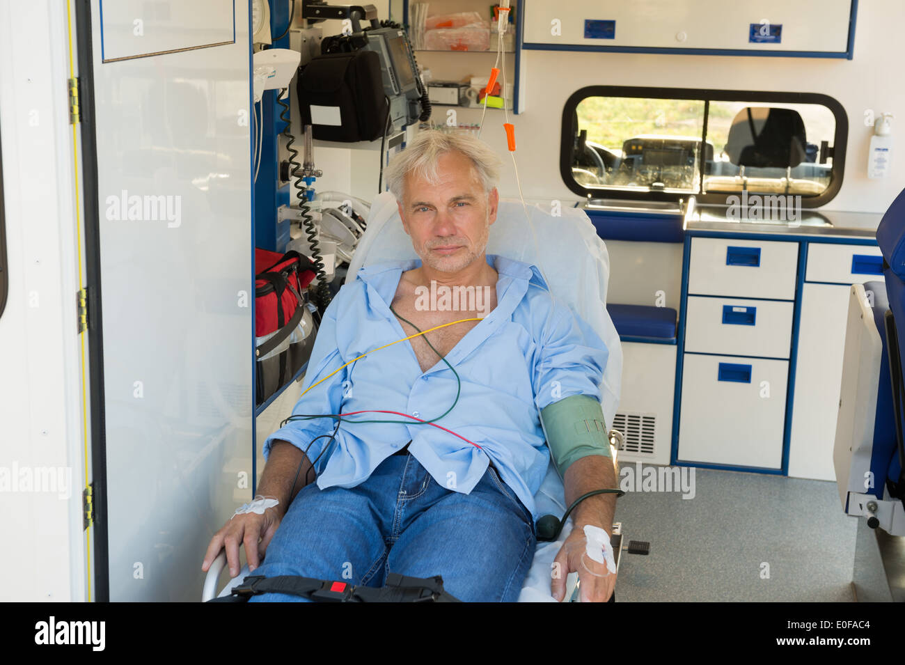 Verletzten senior Mann sitzt auf der Bahre in Krankenwagen Stockfoto
