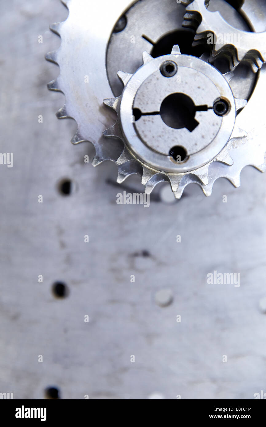 Zahnräder und Getriebe auf einer Metall-Werkbank in einer Herstellungsfabrik Stockfoto