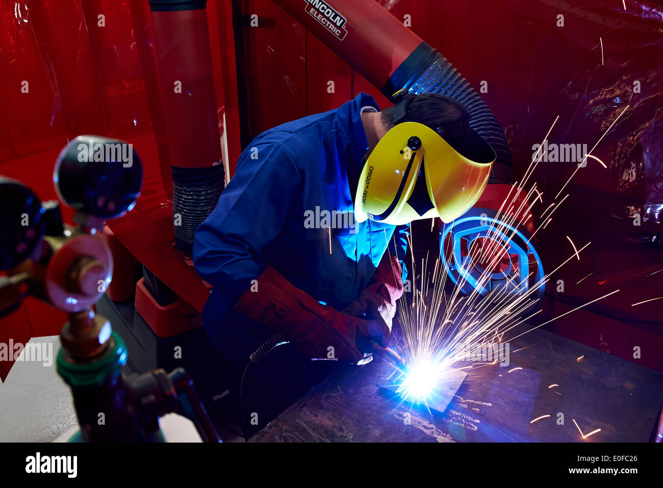 Funken fliegen als Facharbeiter oder Schweißer arbeiten mit Metall in eine UK-Herstellung-Fabrik. Stockfoto