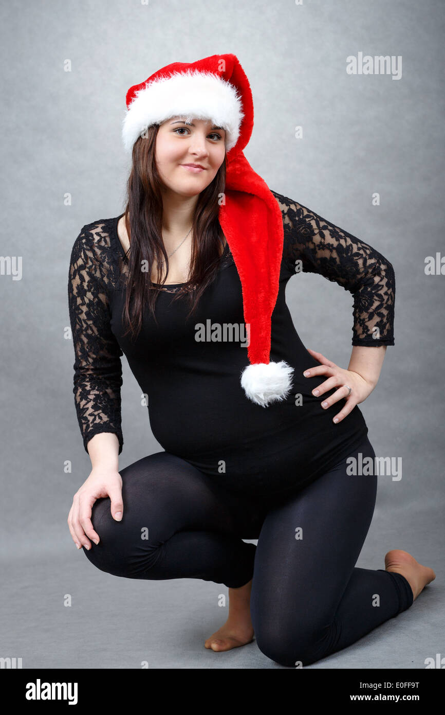 schöne junge Santa schwangeren Bauch zärtlich hält lächelnd Stockfoto