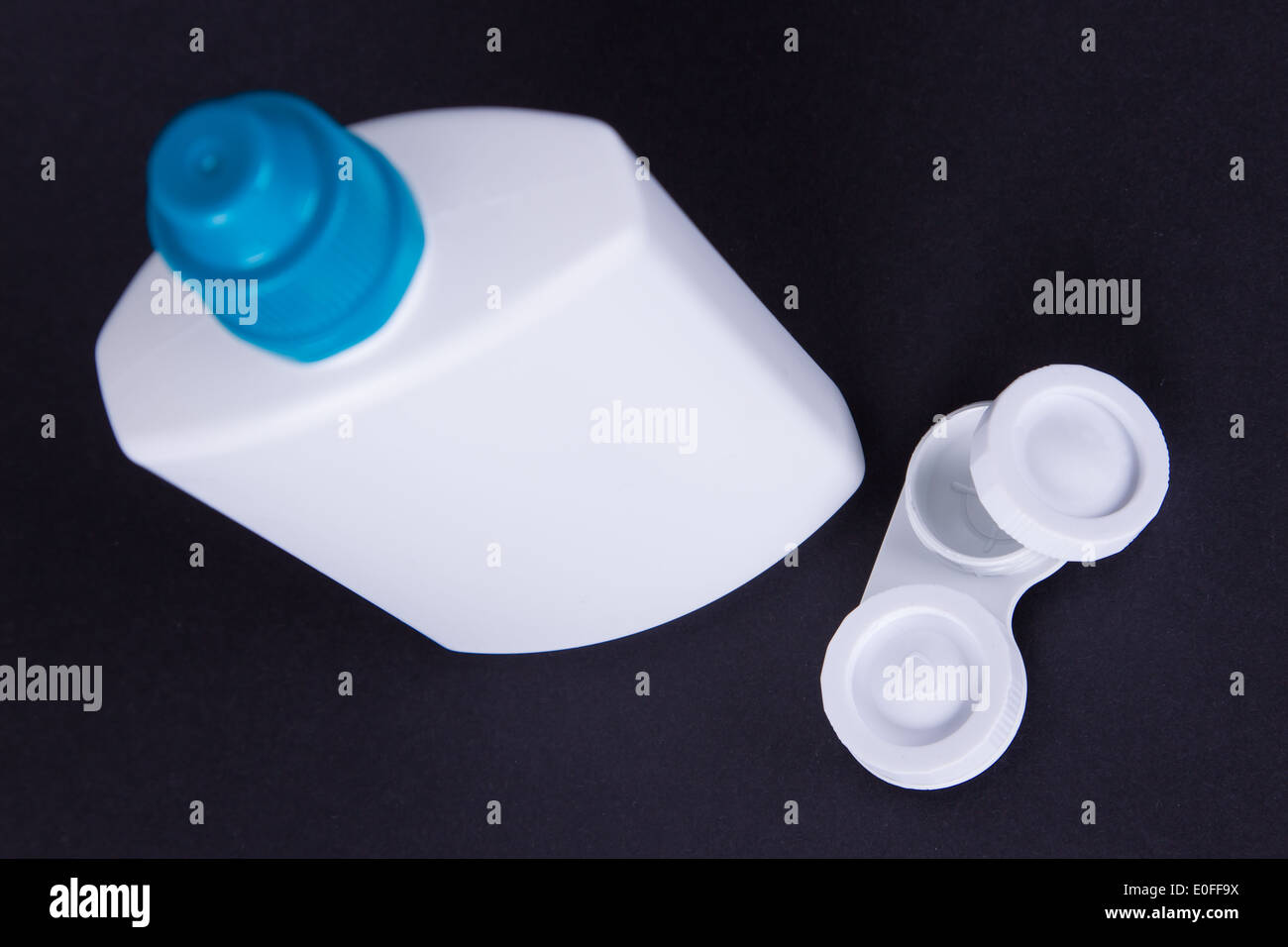 Objektiv-Gehäuse und eine Flasche Wasser isoliert auf schwarz, Kontaktlinsen, selektiven Fokus Stockfoto