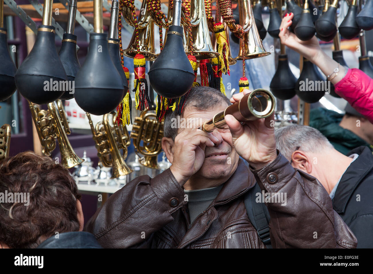 Mann auf der Suche durch ein antikes Teleskop zum Verkauf an der Portobello Road market London Stockfoto