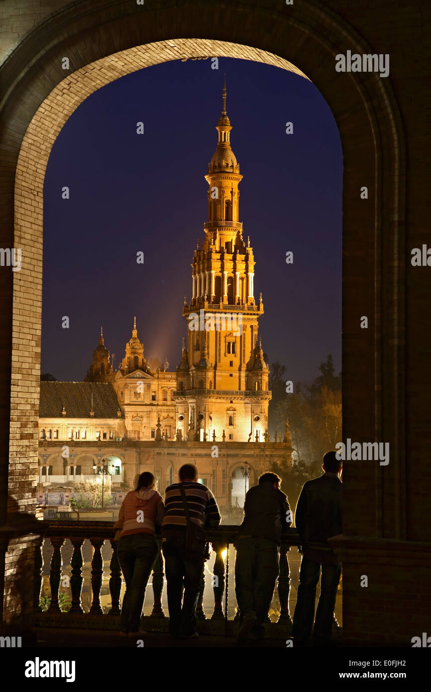 Menschen bewundern Turm durch gewölbte Fenster, Plaza de España in der Dämmerung, Sevilla, Spanien Stockfoto