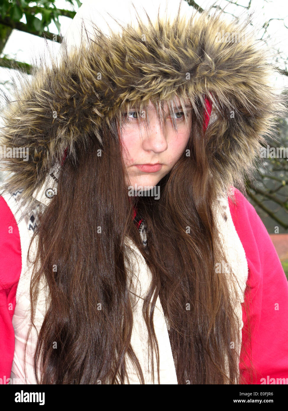 12 Jahre altes Mädchen mit pelzigen Kapuzenjacke schmollen Stockfoto