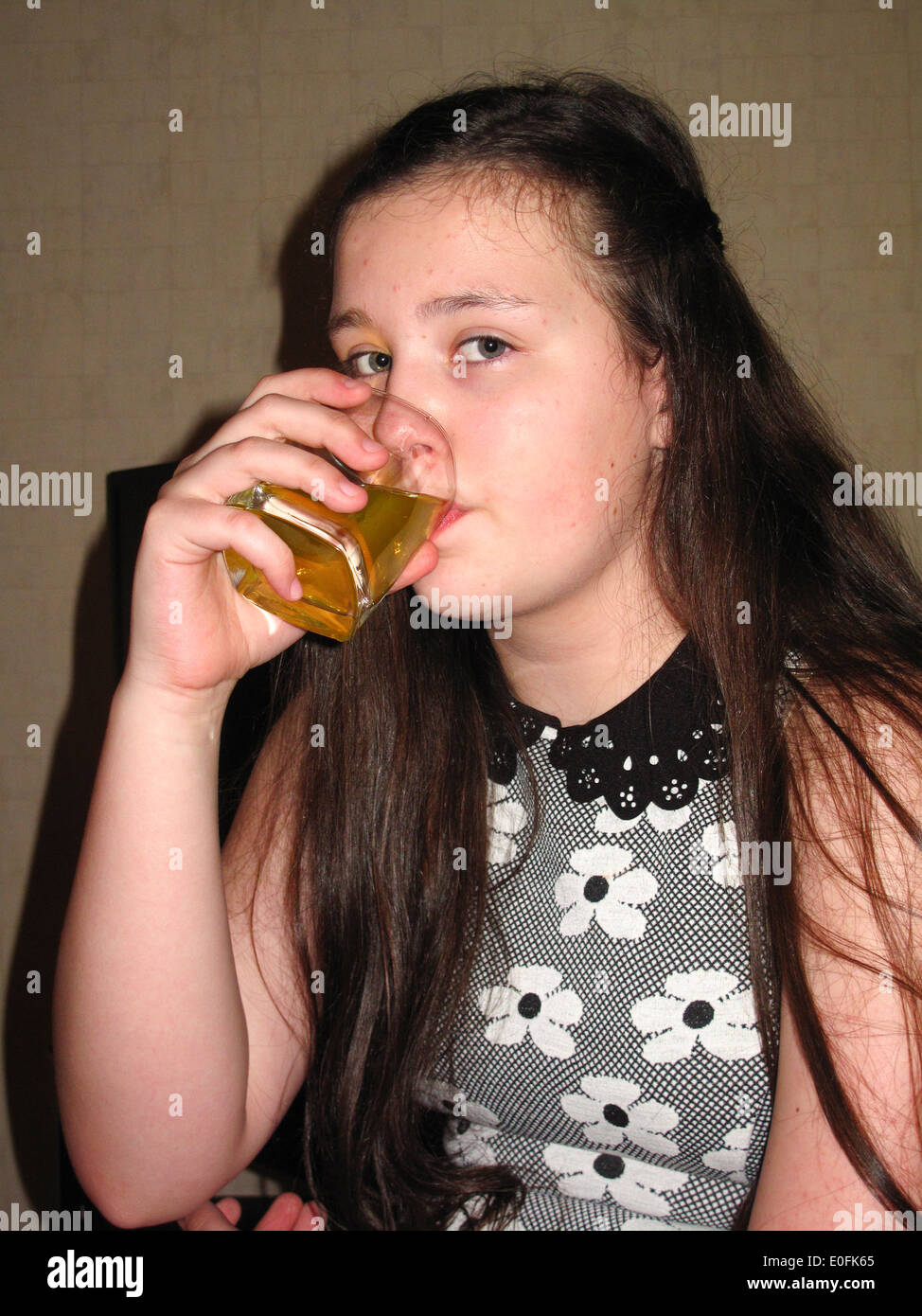 Junges Mädchen trinken aus Glas Sidelit mit flash Stockfoto