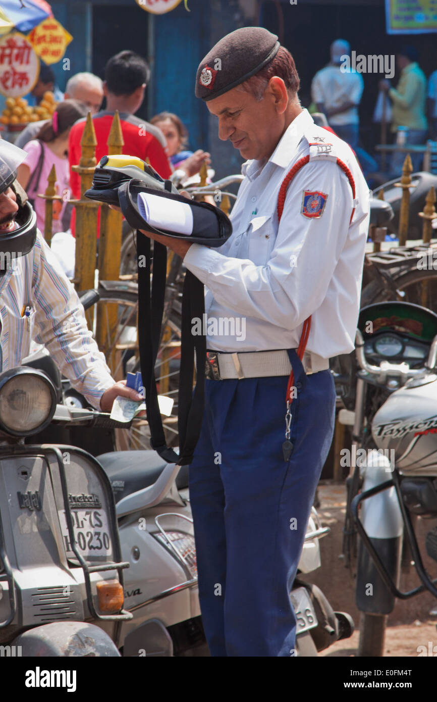 Ein Verkehrspolizist geben, ein Ticket zu einer glücklosen Autofahrer in der Innenstadt von Delhi, Indien Stockfoto