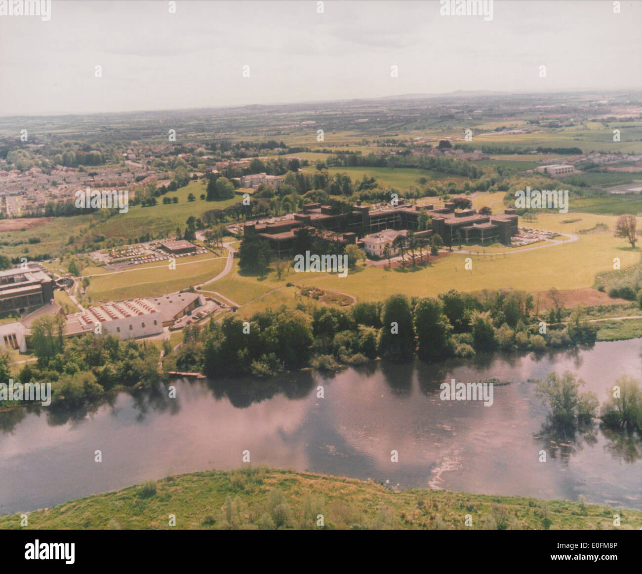 Eine Luftaufnahme eines Universitätscampus auf der anderen Seite des Flusses Shannon, aufgenommen um 1990. Dieses Bild zeigt das Layout und die Architektur des Campus in seiner damaligen Form und spiegelt die Veränderungen in der physischen Umgebung der Einrichtung wider. Stockfoto