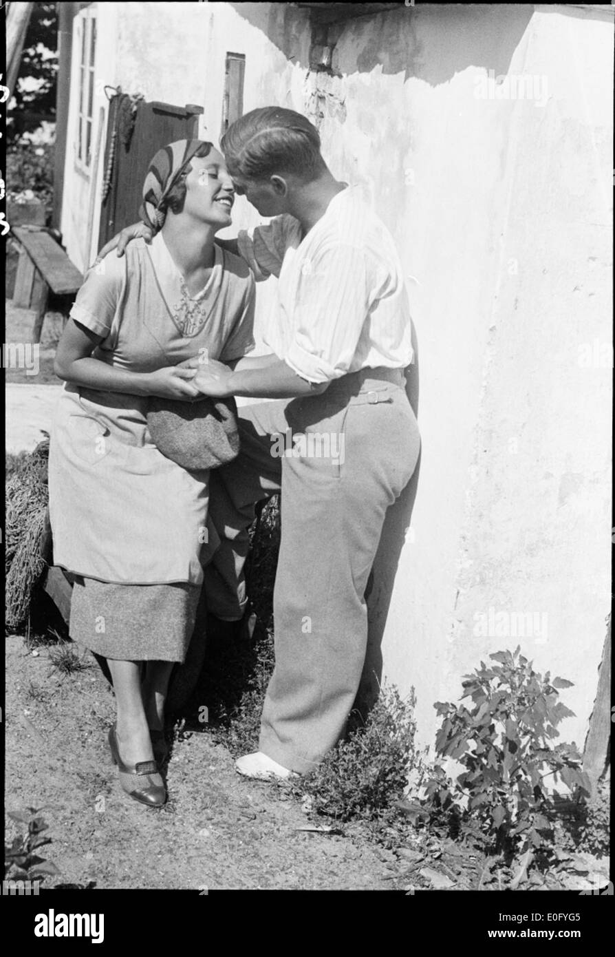 Dieses romantische Schwarzweiß-Bild zeigt ein Paar, das in einer natürlichen Umgebung tanzt. Umgeben von Büschen, Gras und Bäumen, fängt die Szene das Wesen eines friedlichen, intimen Moments im Freien ein. Stockfoto