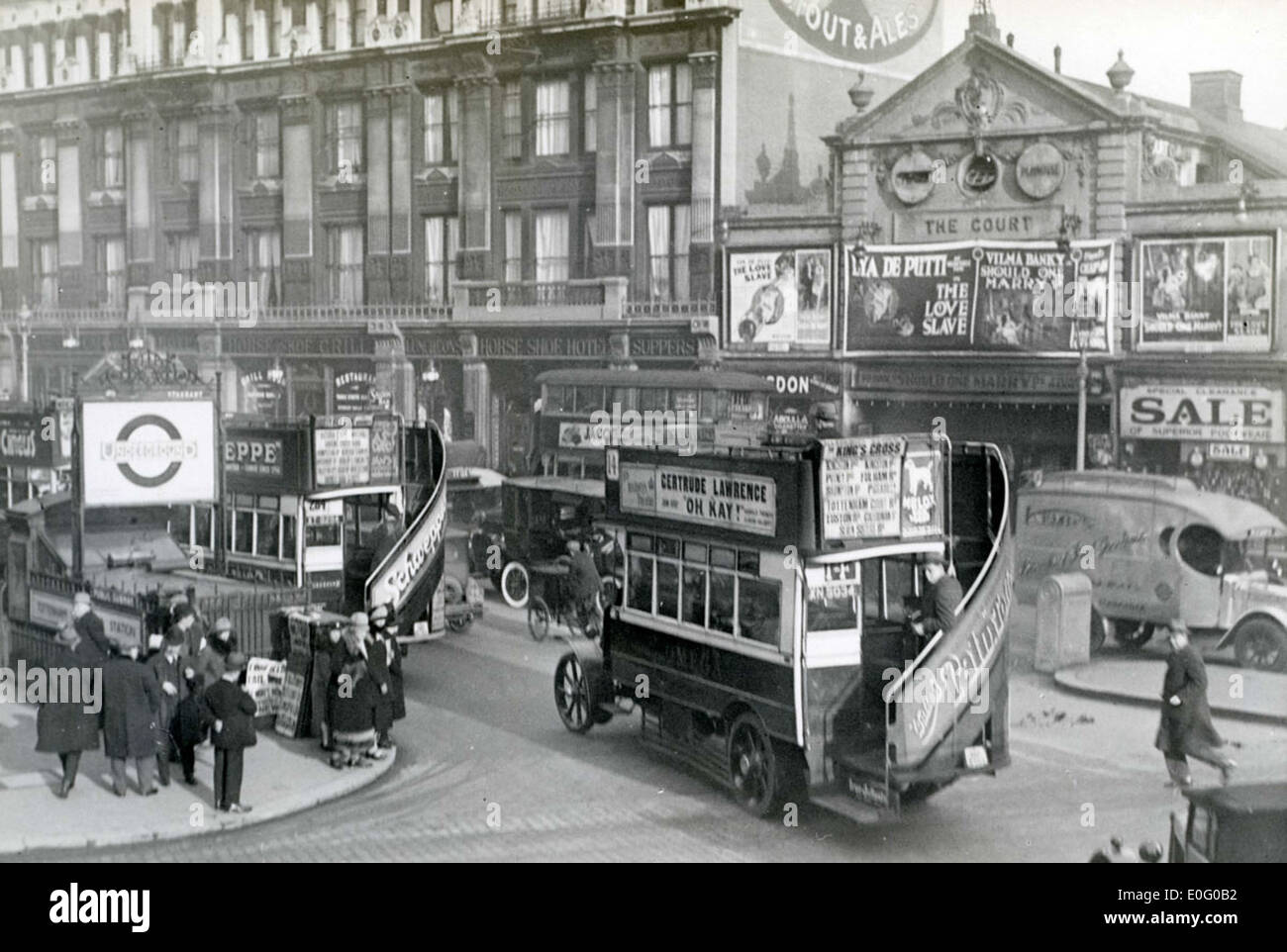 Dieses Bild aus dem Jahr 1927 zeigt die Tottenham Court Road in London und fängt das geschäftige Straßenleben dieser Zeit ein. Die Szene zeigt das Vorhandensein von Verkehrsmitteln und die sich entwickelnde städtische Umgebung. Stockfoto