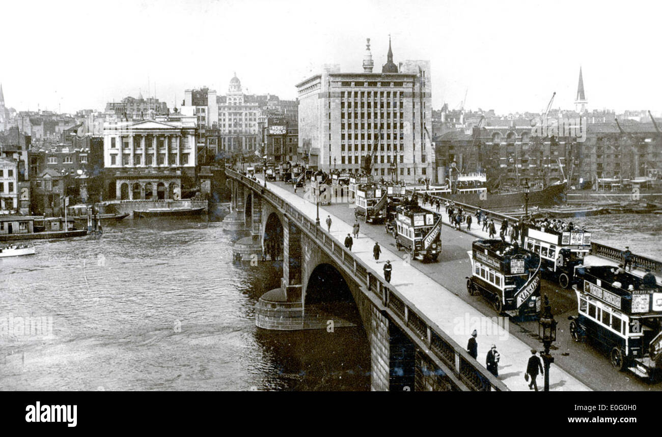 Das Bild des Straßenverkehrs auf der London Bridge aus dem Jahr 1927 zeigt eine geschäftige städtische Umgebung mit Bussen, Fußgängern und Fahrzeugen, die die berühmte Brücke überqueren. Dieses Foto zeigt die Hektik des Londoner Verkehrssystems Ende der 1920er Jahre und spiegelt das Wachstum und die Modernisierung der Stadt wider. Stockfoto