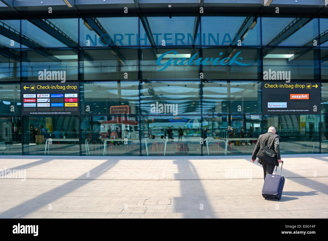 Reisende, die zu Fuß in Richtung Check-in London Gatwick Airport North Terminal Building Stockfoto