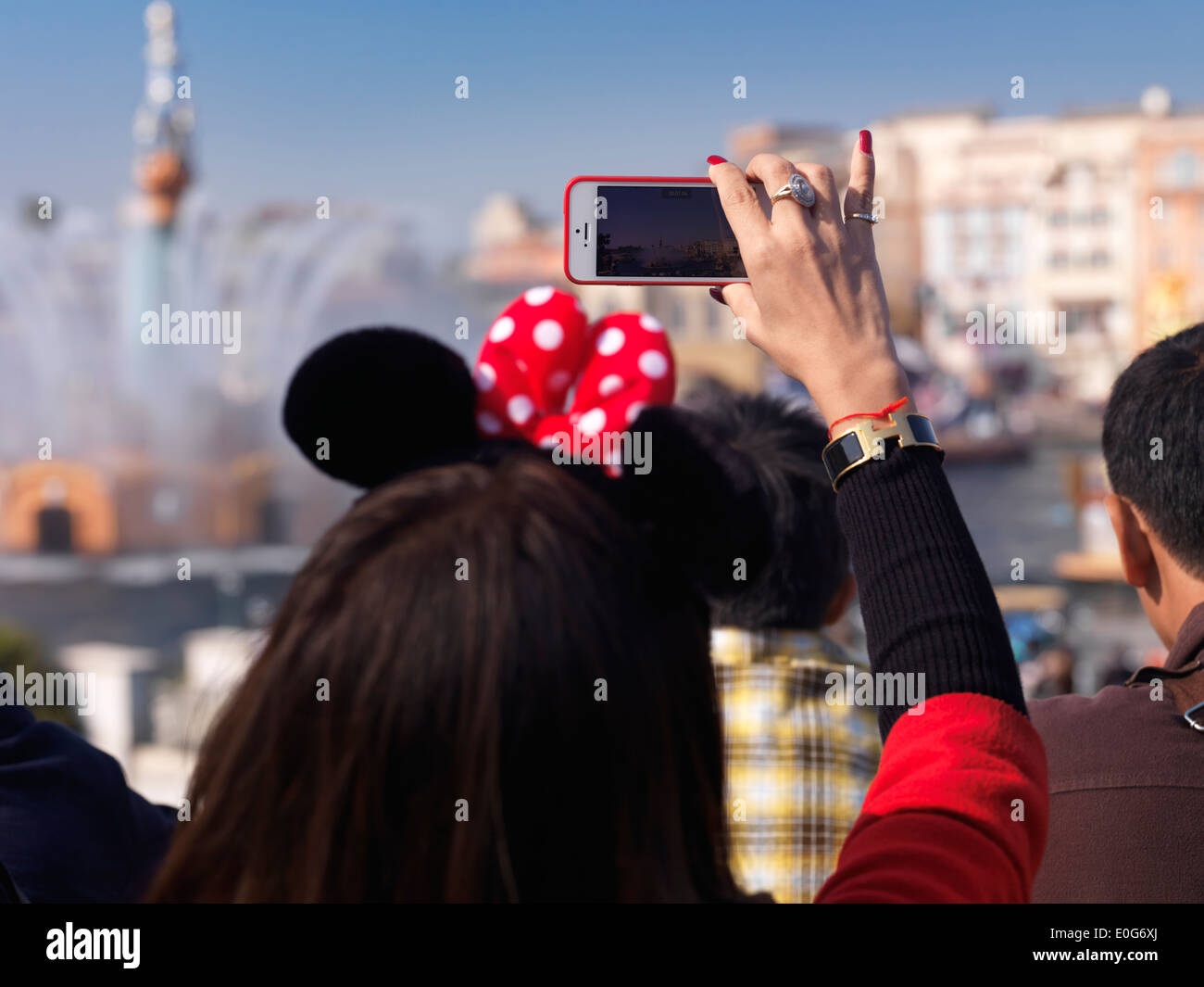 Frau fotografieren mit dem iPhone eine Show im Tokyo Disneysea Themenpark. Japan. Stockfoto